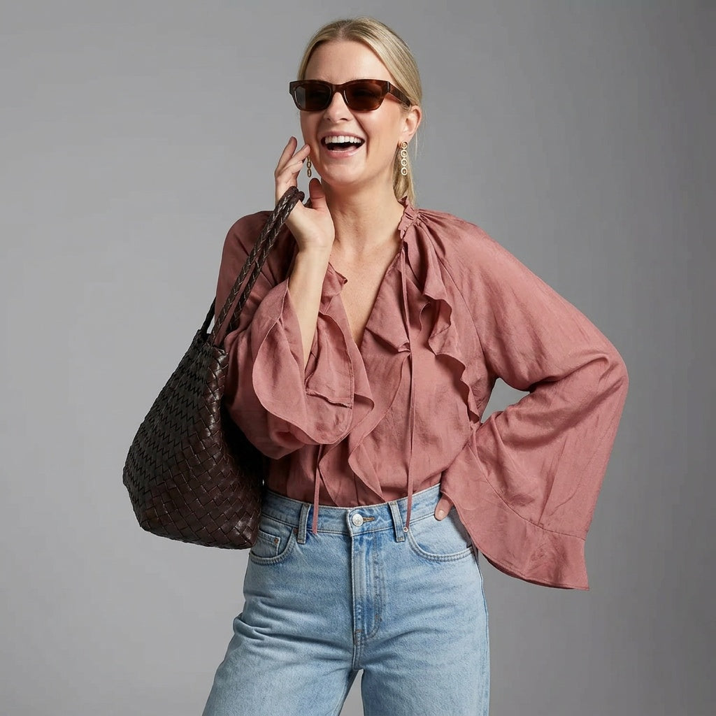 Professional e-commerce product photography, edit the provided images. Use the provided image as the product. Preserve the exact product shape, logo, colors, textures, and proportions. Do not alter, reshape, recolor, or add features to the product. clean studio backdrop, neutral grey gradient, flat even lighting, minimal shadows. upper body shot, waist up, torso and shoulders visible. joyful expressive face, laughing or mid-laugh, candid emotion. one hand raised near face, other hand resting on hip, legs cr